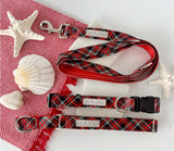 Festive red plaid dog accessories arranged with shells and starfish.