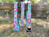 Bright floral dog collars and leash hanging on a wooden fence.
