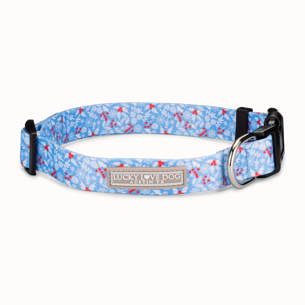 Light blue winter-themed dog collar by Lucky Love Dog Austin with snowflake and red berry pattern and metal D-ring.