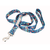 Blue holiday-themed dog leash by Lucky Love Dog Austin with festive ornament and foliage pattern and a metal clasp.