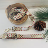 Matching Lucky Love Dog leash and collar in a holiday pattern displayed with pine and a wooden bowl.