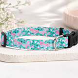 Floral patterned dog collar on a white surface with a soft blurred background